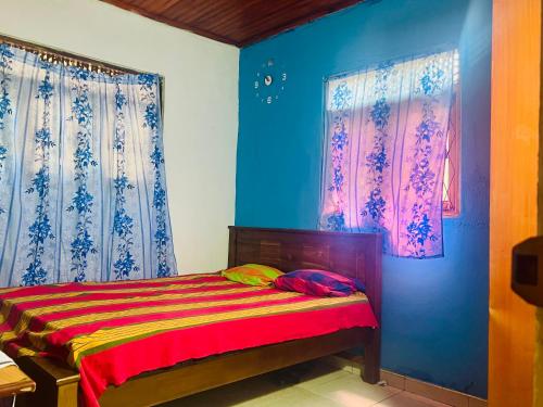Habitación con cama con paredes y ventanas azules. en Kalanı villa, en Kotugoda