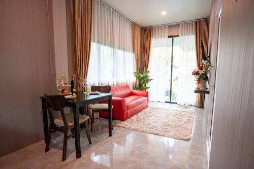 a living room with a red couch and a table at SeeView Resort (ซีวิว รีสอร์ต) in Ban Pak Nam