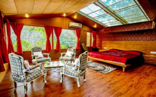 a bedroom with a bed and chairs and a window at CARAVAN SERAI in Jambughoda