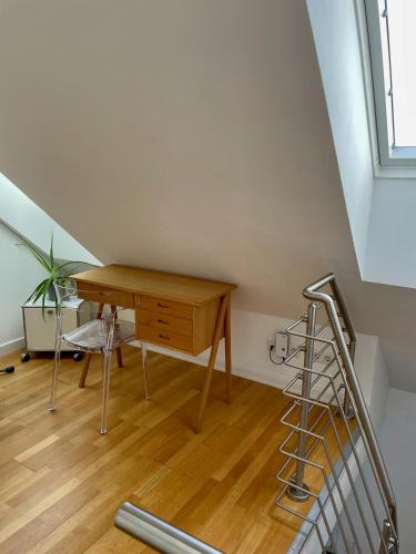 a desk and chair in a room with a staircase at The Suites City Lofts at the Park in Hamburg