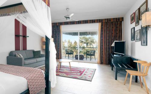a bedroom with a bed and a living room at TUI BLUE Bahari Zanzibar in Pwani Mchangani