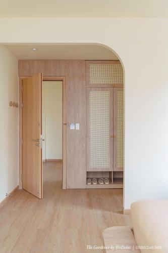 an empty room with two doors and a room with wooden floors at The Gardener by WeDalat in Da Lat
