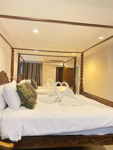 two swans sitting on a bed in front of a mirror at The Guest Hotel & Hostel in Chiang Mai