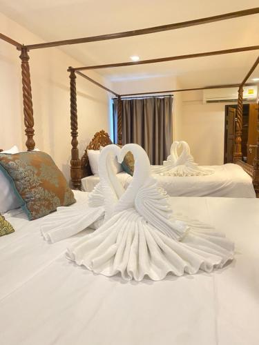 two swans made out of white sheets on a bed at The Guest Hotel & Hostel in Chiang Mai