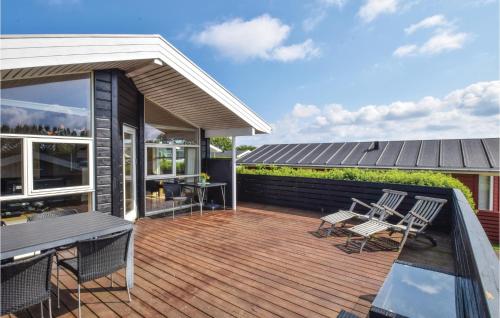 a deck with chairs and a table on a house at Søhus in Fæbæk