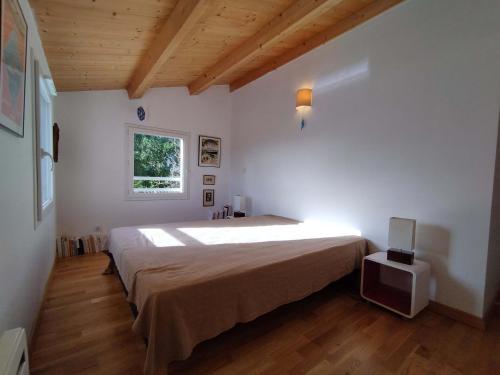 une chambre avec un grand lit et une fenêtre dans l'établissement Maison avec Piscine Chauffée, Proche Plages et Commodités, Wifi/Fibre, Piano – Chéray, Oléron - FR-1-778-8, à Saint-Georges-dʼOléron