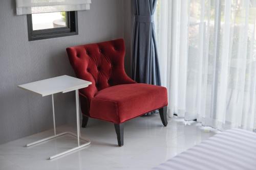 a red chair and a white table in a room at SeeView Resort (ซีวิว รีสอร์ต) in Ban Pak Nam
