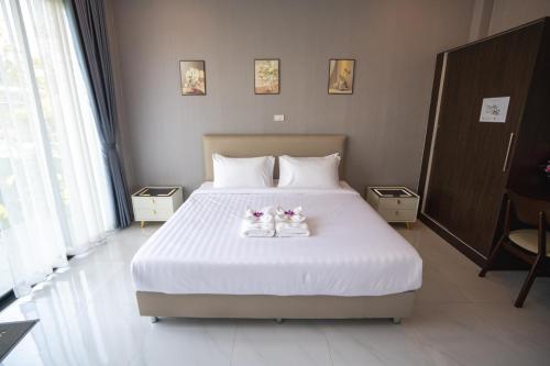 two cats sitting on a bed in a bedroom at SeeView Resort (ซีวิว รีสอร์ต) in Ban Pak Nam