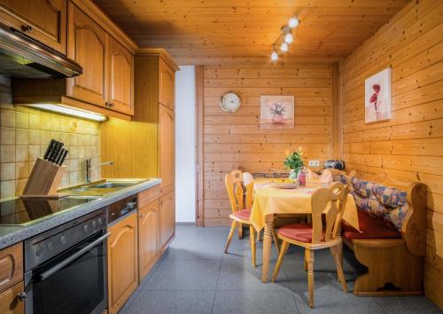 a kitchen with a table and chairs in a room at Haus Annemarie Apartments Kartitsch - Hochpustertal in Kartitsch