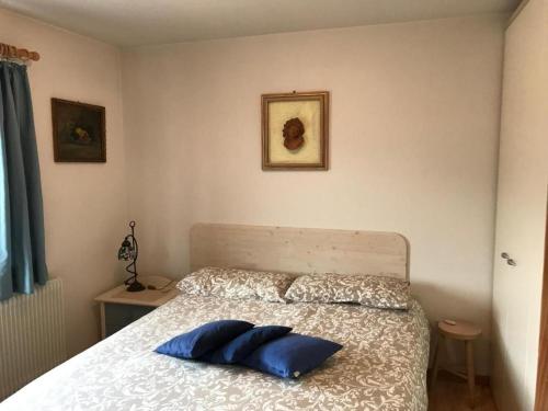 una camera da letto con un letto con due cuscini blu sopra di Suite Marco, Cavalese. CIPAT 022050-AT-993709 a Cavalese