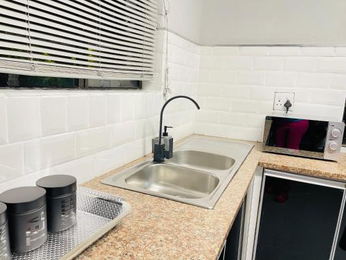 a kitchen counter with a sink in a kitchen at Pelican Apartment in Durban