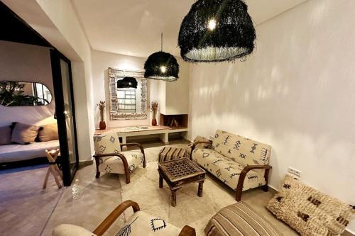 - un salon avec un canapé, des chaises et une table dans l'établissement Riad Wadiya, privatif, piscine en rooftop., à Marrakech
