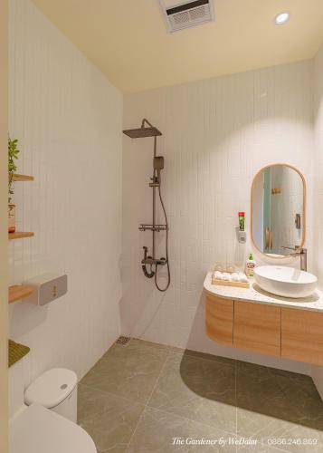 a bathroom with a sink and a toilet and a mirror at The Gardener by WeDalat in Da Lat