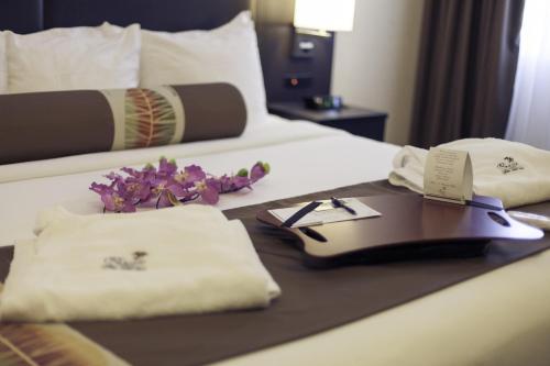 a hotel room with a tray of food on a bed at L'Escale Hôtel Suites in Val-dʼOr