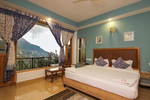 - une chambre avec un lit et une grande fenêtre dans l'établissement Starlit Getaway, à Dharamshala
