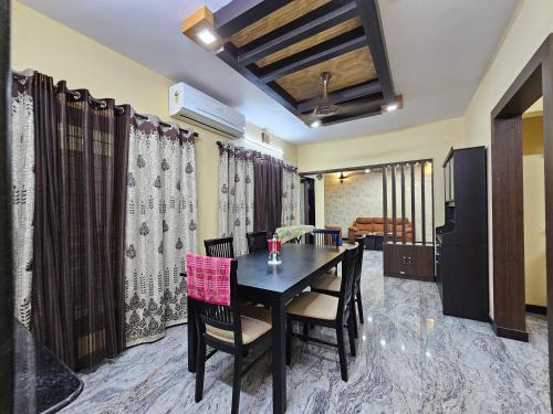 uma sala de jantar com mesa e cadeiras em Fully Airconditioned Uber Luxurious Holiday Home. em Kundapur