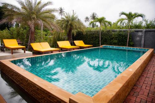 a swimming pool with yellow chairs and a swimming pool at Viangviman Luxury Resort, Krabi in Ao Nang Beach
