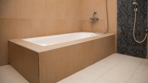 a bath tub in a bathroom with a shower at Sai Residency ECR in Chennai