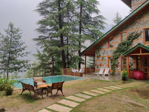 a house with a swimming pool in front of it at Kudrat - A Boutique Homestay- Tirthan Valley in Banjār