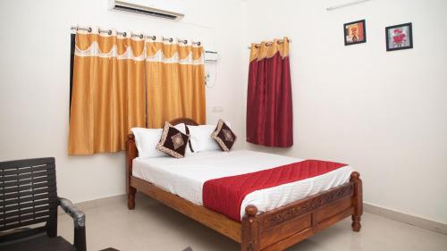 a bedroom with a bed and a window with curtains at Sai Residency ECR in Chennai