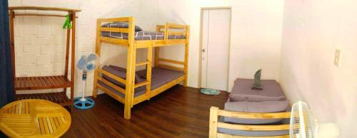 a room with two bunk beds and a table at CocoHut Beach House in Locaroc