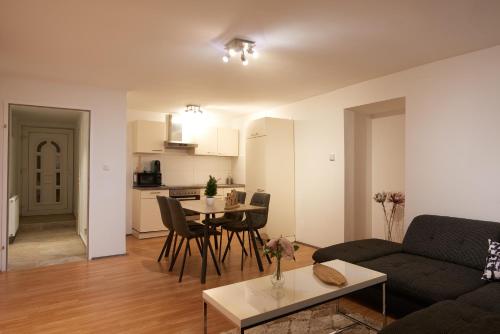 ein Wohnzimmer mit einem Sofa und einem Tisch in der Unterkunft Spacious Apartment near Schoenbrunn Castle in Wien