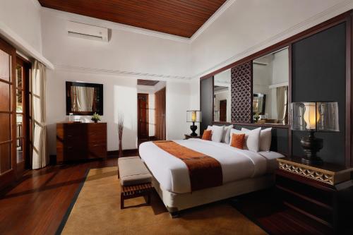 a bedroom with a large bed and a mirror at Jimbaran Beach Villas by Nakula in Jimbaran