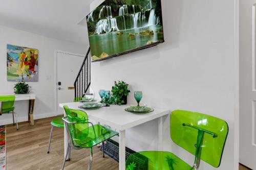 a dining room with a white table and green chairs at The Worthington - 3 BR 2 5 Bath and Parking in Columbus