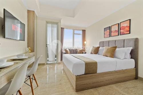 een slaapkamer met een groot wit bed en een tafel bij Nyansa by Kozystay - Menteng in Jakarta