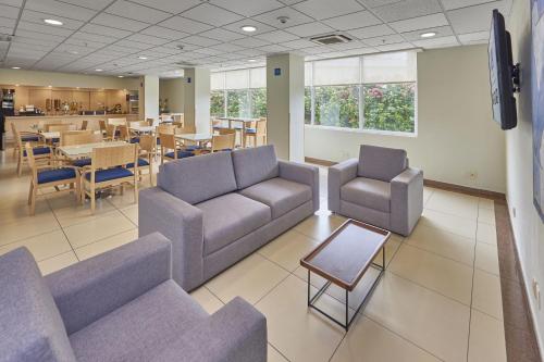 a waiting room with couches and a table and chairs at City Express by Marriott Culiacan in Culiacán
