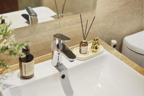 een wastafel met een zeepdispenser bij Nyansa by Kozystay - Menteng in Jakarta
