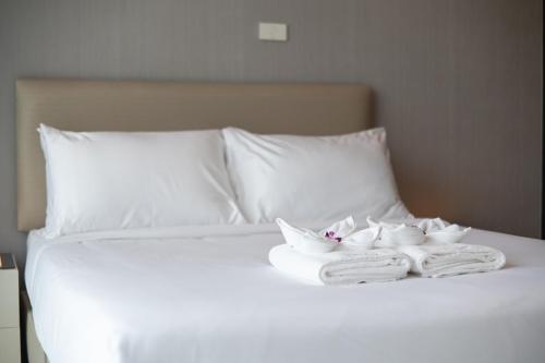 a white bed with two towels and two robes at SeeView Resort (ซีวิว รีสอร์ต) in Ban Pak Nam