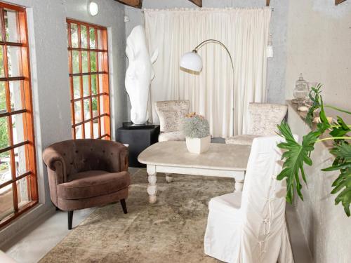 uma sala de estar com uma cadeira e uma mesa em Muckleneuk Manor em Pretoria
