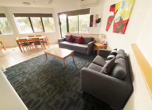 a living room with a couch and a table at Tiki Hotel Apartments Surfers Paradise in Gold Coast