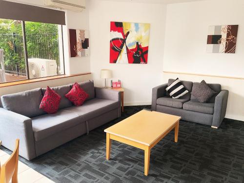 a living room with two couches and a coffee table at Tiki Hotel Apartments Surfers Paradise in Gold Coast