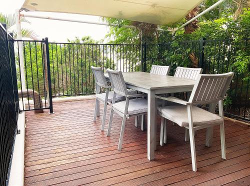 a white table and chairs on a deck at Tiki Hotel Apartments Surfers Paradise in Gold Coast
