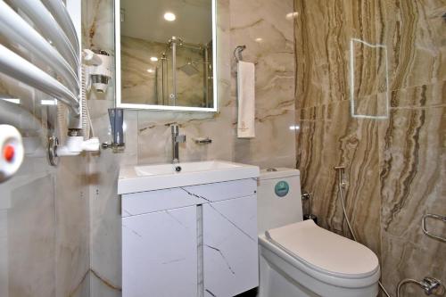 a bathroom with a toilet and a sink and a mirror at Avenue 23 Boutique Hotel in Yerevan
