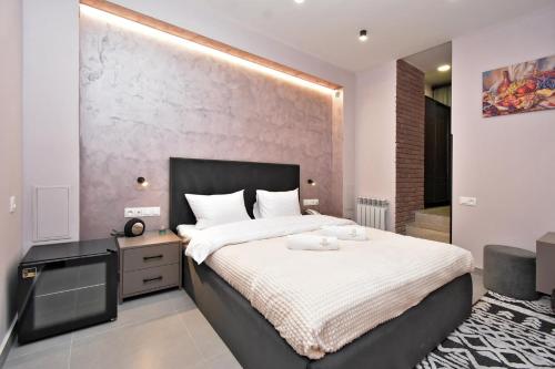 a bedroom with a large bed with a black headboard at Avenue 23 Boutique Hotel in Yerevan
