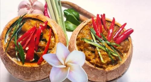 duas tigelas de comida com vegetais e uma flor em Natural bungalows em Kampong Cham