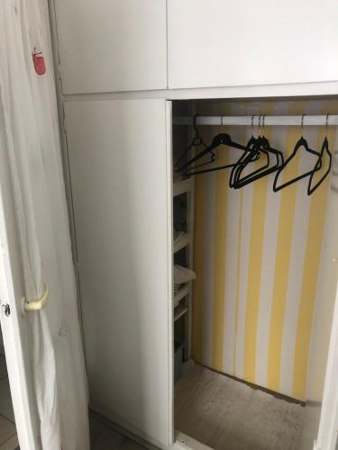 a cupboard with a glass door with hangers at Cosy66 in Kaposvár