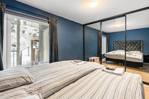 1 cama grande en un dormitorio con una pared azul en Arctic Suite - 5 minutes from city centre, en Tromsø