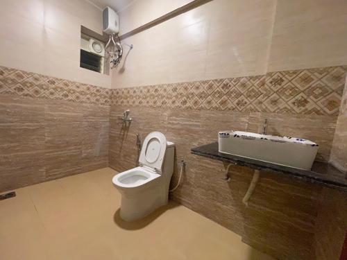 a bathroom with a toilet and a sink at Baga Keys by RJ14 in Old Goa