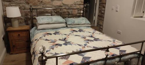 a bed with a quilt on it in a bedroom at The Old House at Belfield in Tralee