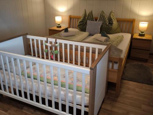 - un lit bébé dans une chambre avec lit bébé dans l'établissement Riverside Appartements, à Lieserbrücke