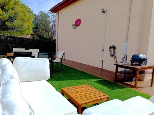 eine Terrasse mit einem Sofa, einem Tisch und Gras in der Unterkunft Secrets of Montserrat in El Bruc