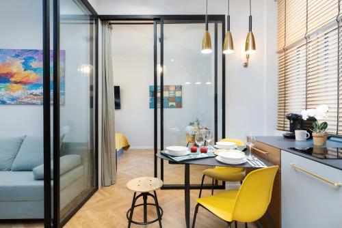 a kitchen and living room with a table and yellow chairs at Apartament Nad Motławą Seredyńskiego by Renters in Gdańsk