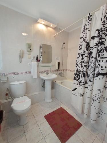 a bathroom with a toilet and a sink and a tub at Гостиница ИЛЕК in Aktobe