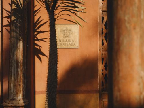 a shadow of a palm tree on a wall at Al Moudira Hotel in Luxor