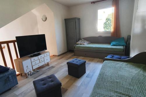 un salon avec un canapé et une télévision à écran plat dans l'établissement Appartement Duplex tout confort, à Pierrefiche