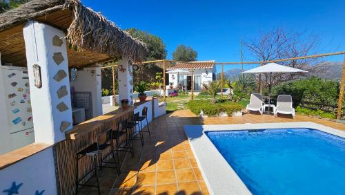 een villa met een zwembad en een patio bij Casita Johanna in Viñuela